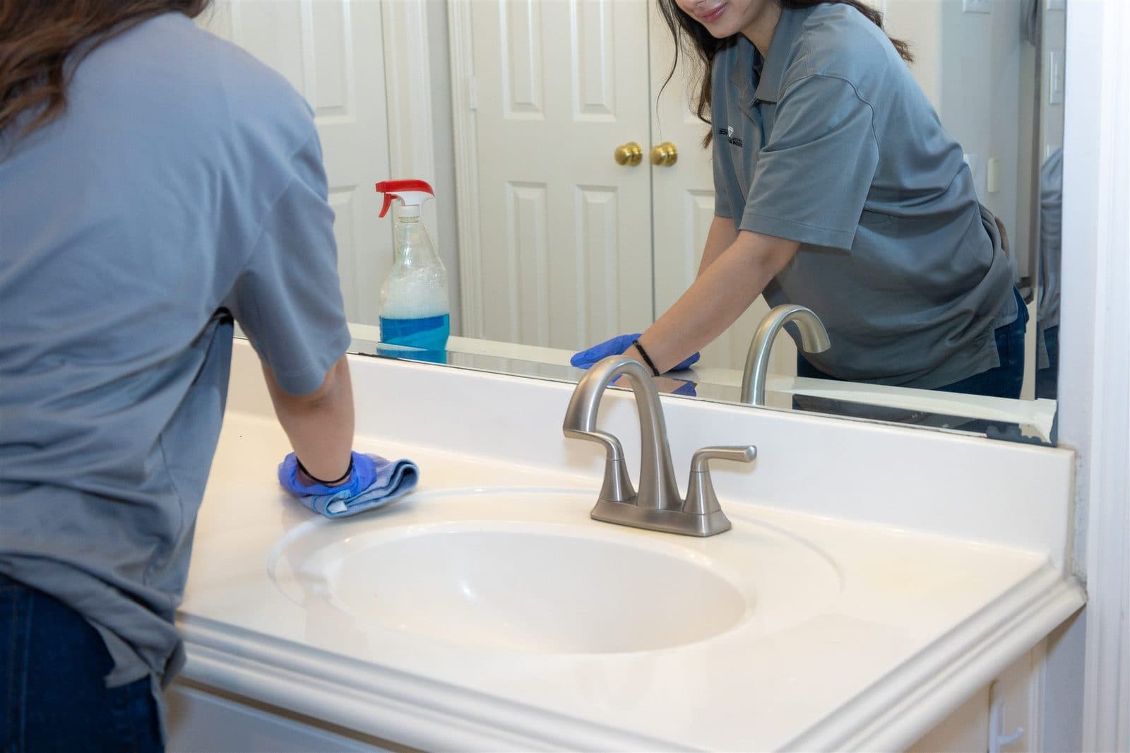 Cleaner polishing a mirror